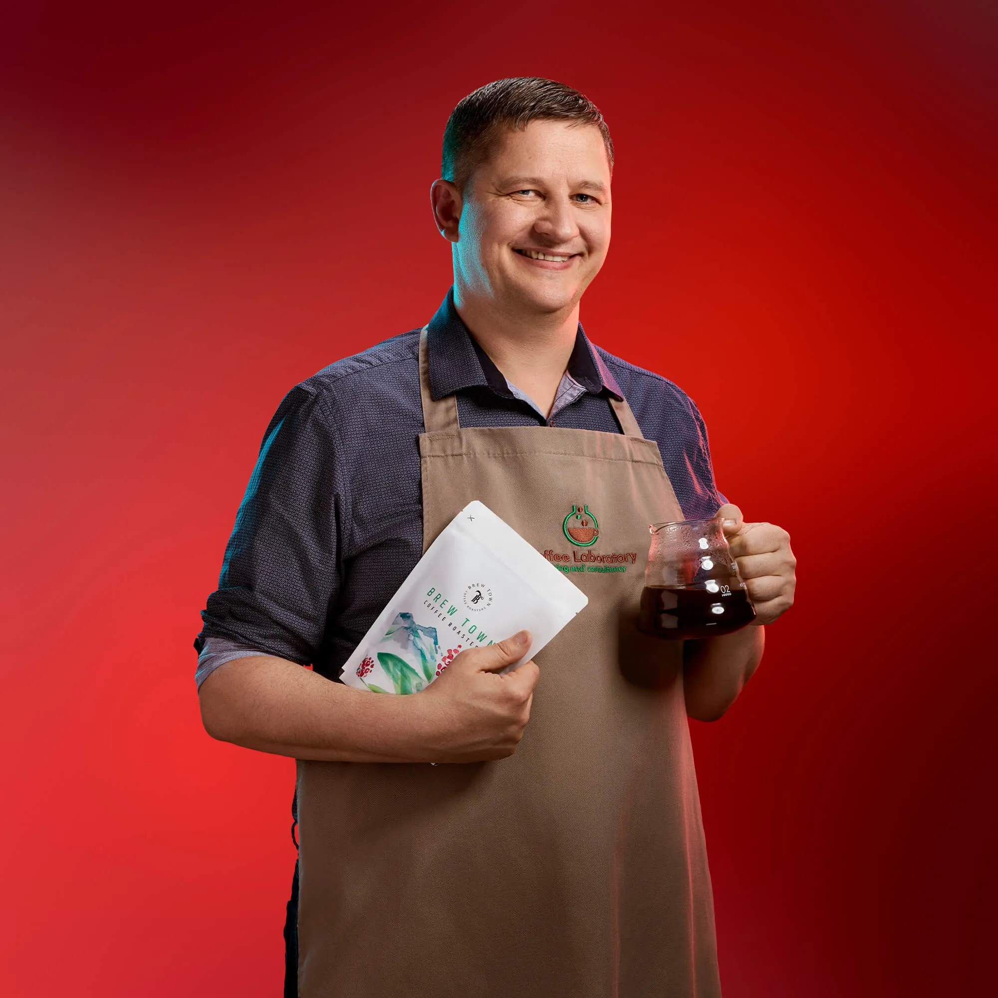 An image of a man wearing an apron and holding a coffee jug on a red background | FBD Insurance